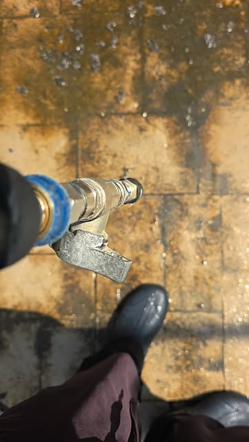 Close-up of the surface cleaner nozzle lifting grime off pavers.